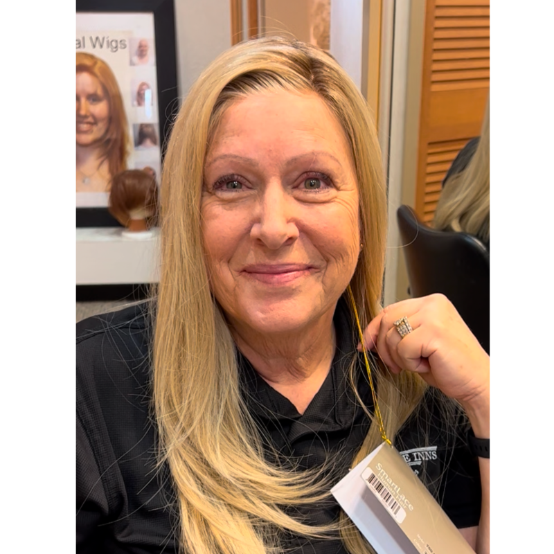 Caucasian woman smiling in a silky, natural-looking human hair lace wig with lace front.