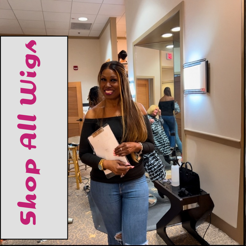 Black woman standing in fitting room holding a clipboard with customers in the background, next to a banner that says ‘Shop All Wigs’ – empowering women experiencing hair loss from alopecia, chemotherapy, or thinning edges.